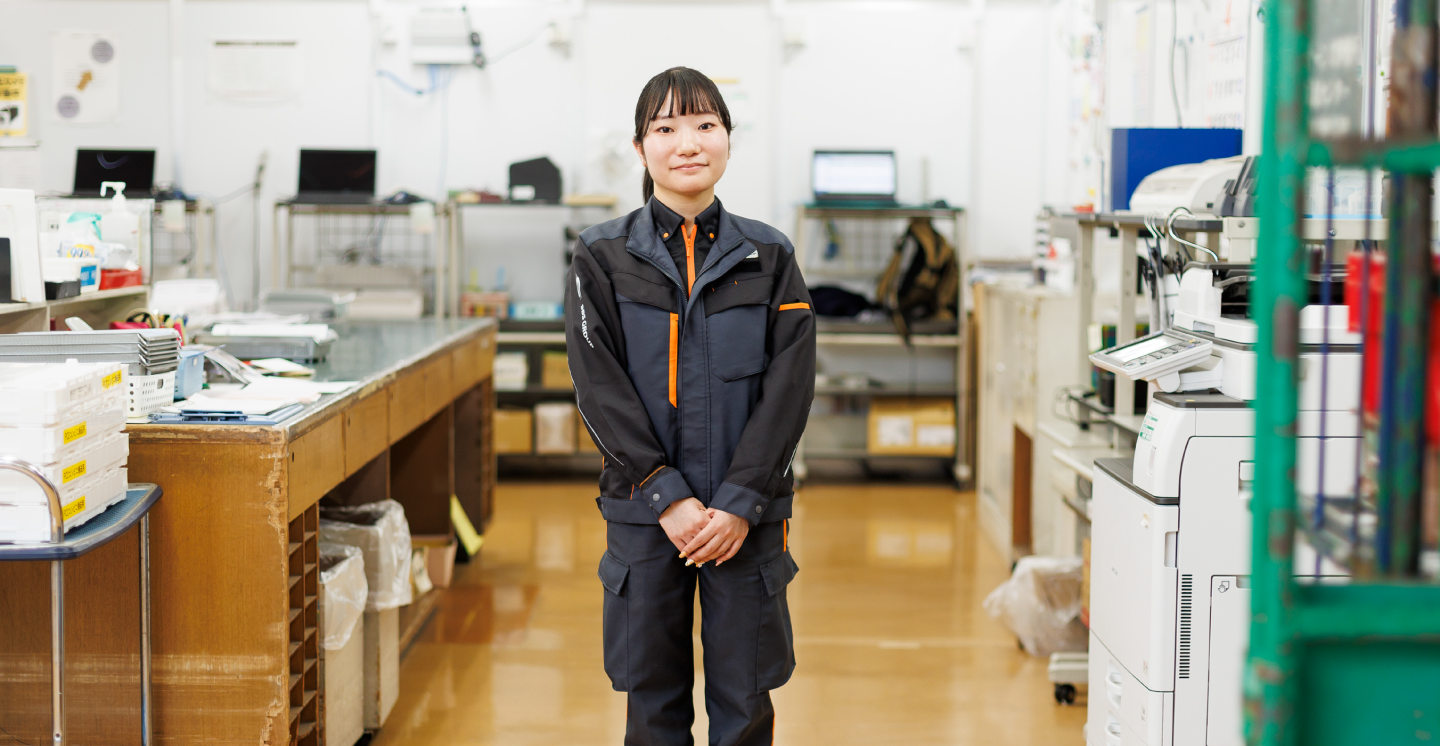 笑顔で職場に立つ女性庫内オペレーター