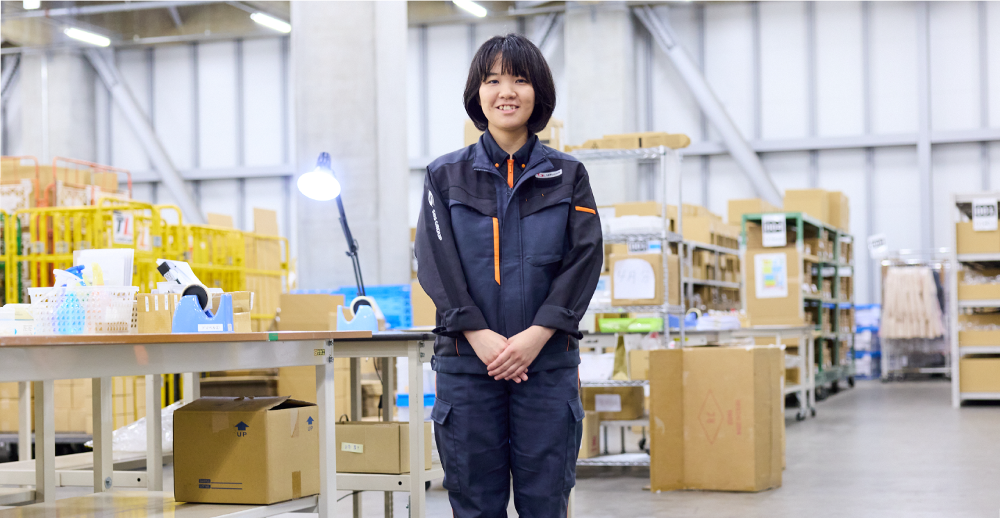 笑顔で職場に立つ女性庫内オペレーター