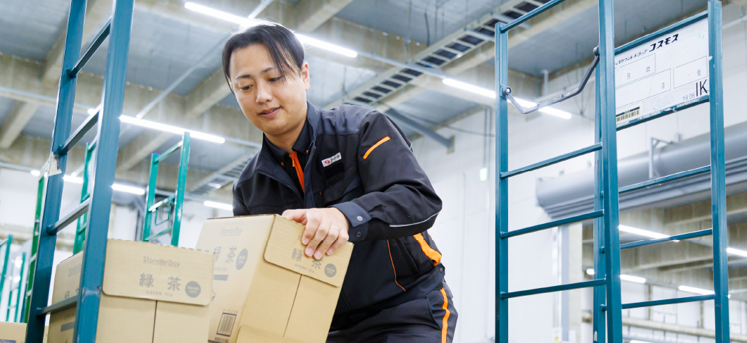 荷物を手作業で運ぶ男性物流管理スタッフ