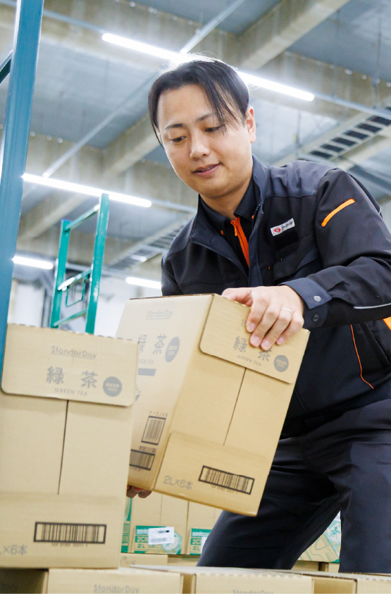 荷物を手作業で運ぶ男性物流管理スタッフ