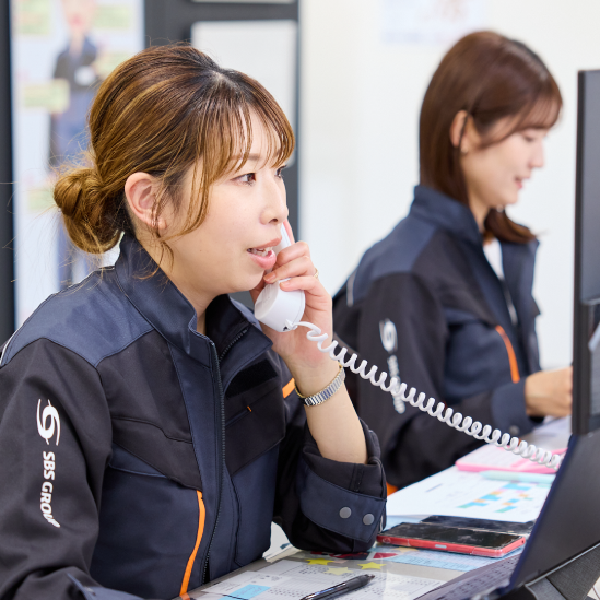 職場で電話で話す女性物流管理係長