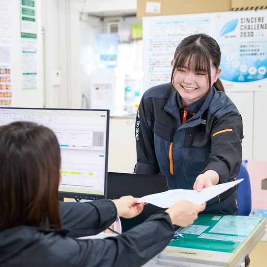 職場で書類を受け取る女性物流管理スタッフ