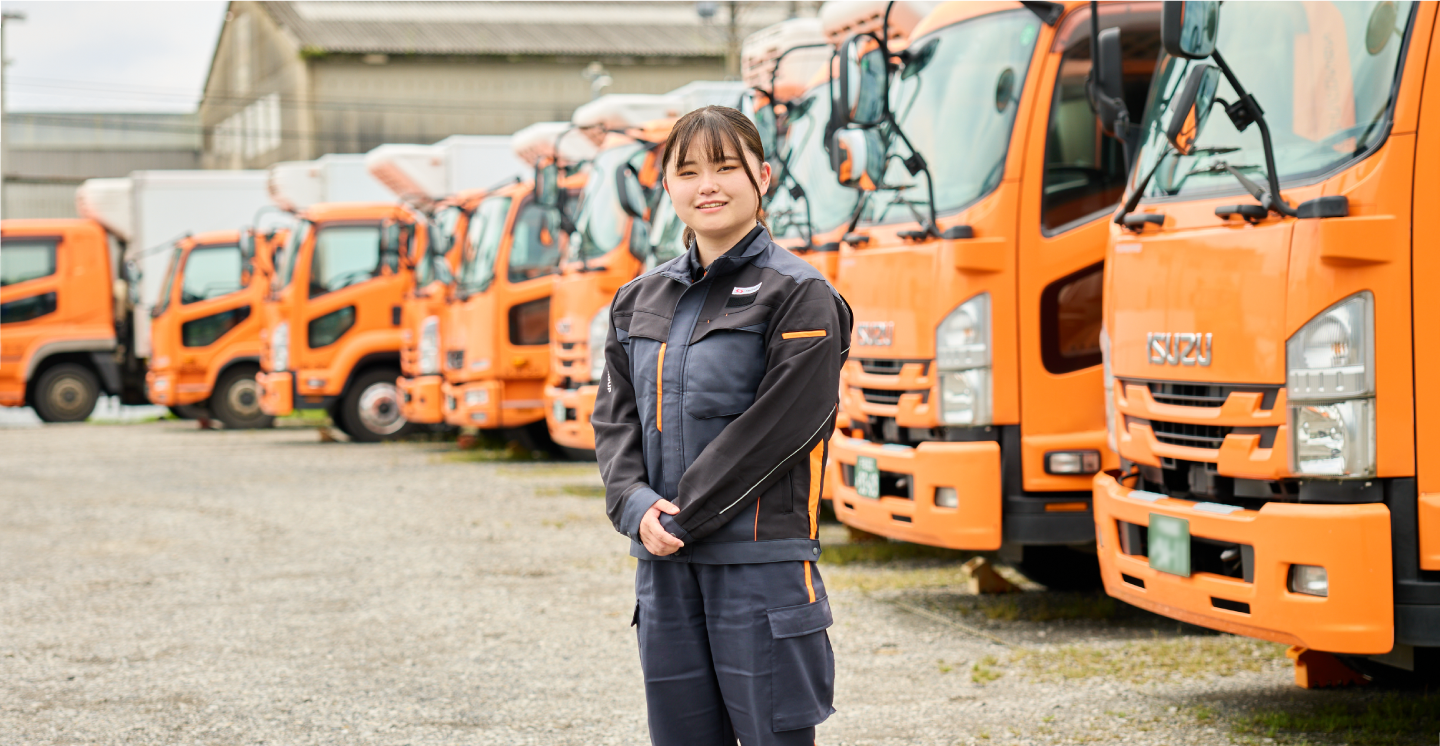 トラックの前に立つ女性物流管理スタッフ