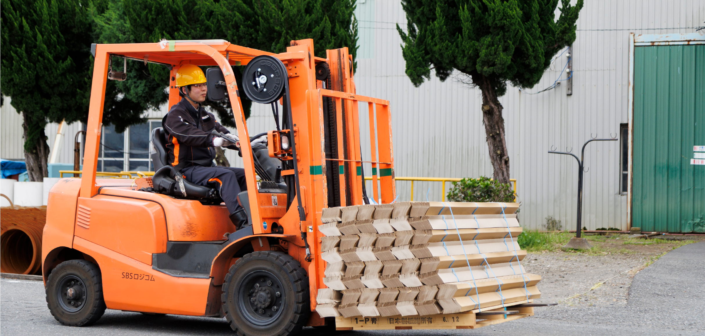 フォークリフトで荷物を運ぶ男性オペレーター