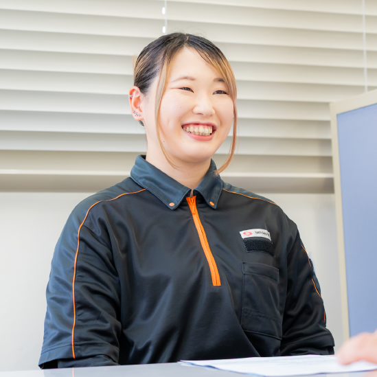 笑顔でインタビューに応じる女性物流管理スタッフ
