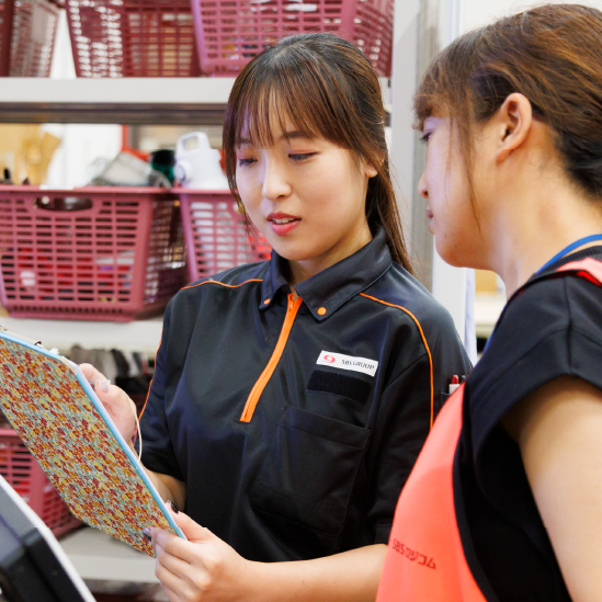 別スタッフに情報確認する女性スタッフ