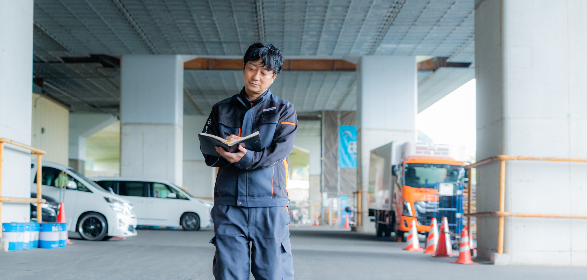 メモしながら倉庫を歩く支店長