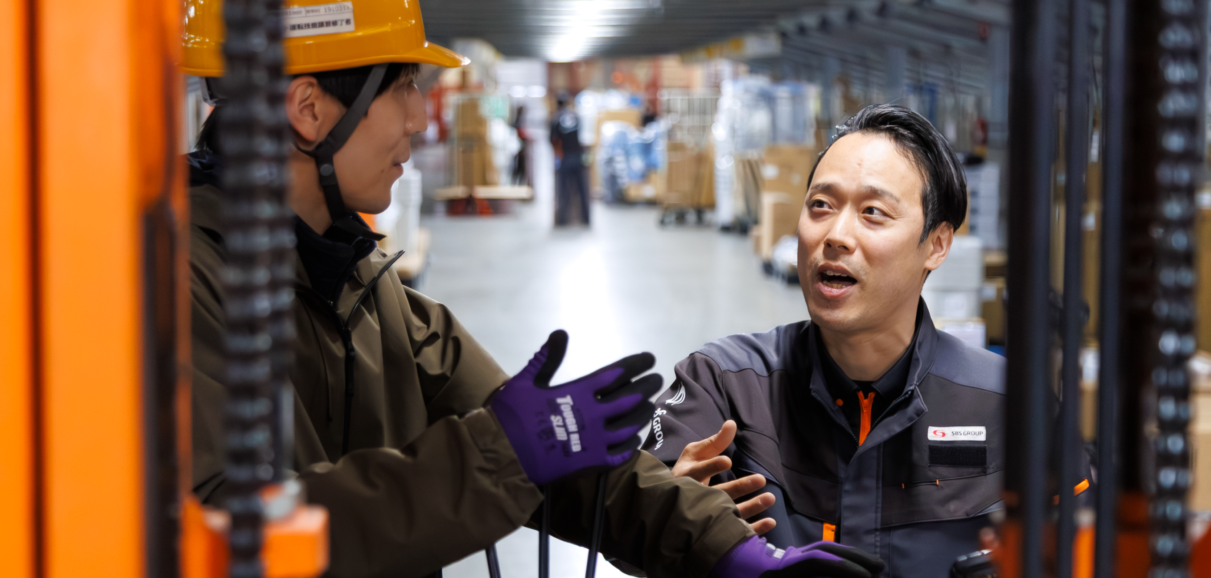 フォークリフトオペレーターと話す物流管理スタッフ