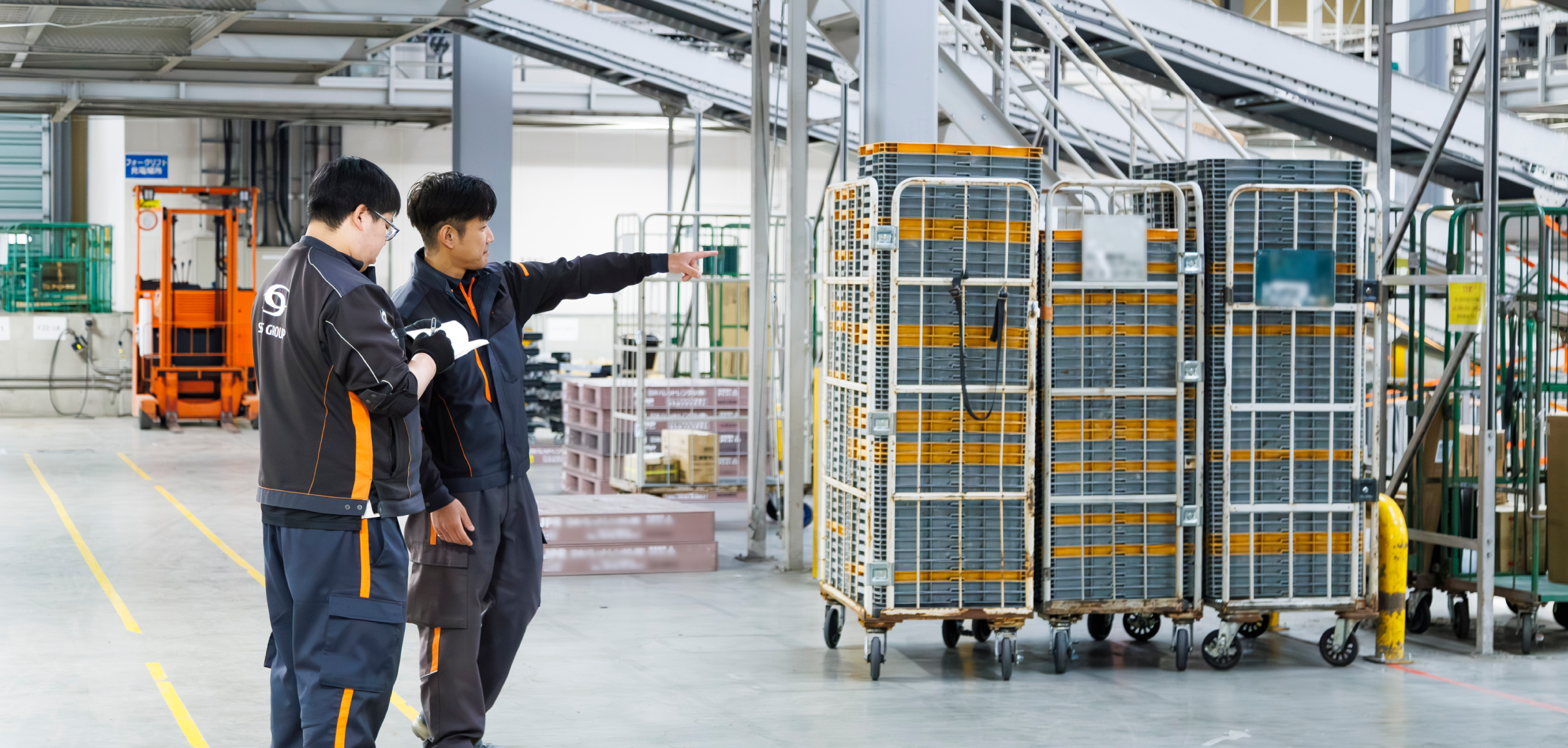 倉庫内でスタッフに指示を出す物流管理スタッフ