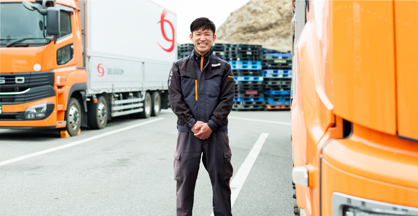 駐車場でポーズをとる物流管理スタッフ