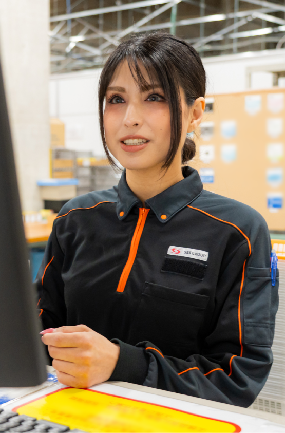 倉庫でPCでチェックする女性スタッフ